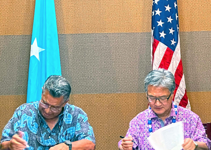 FSM Chief Negotiator Leo Falcam Jr (left) and US Presidential Envoy Joseph Yun in Pohnpei initial a nearly final version of the funding agreement for extending the Compact of Free Association