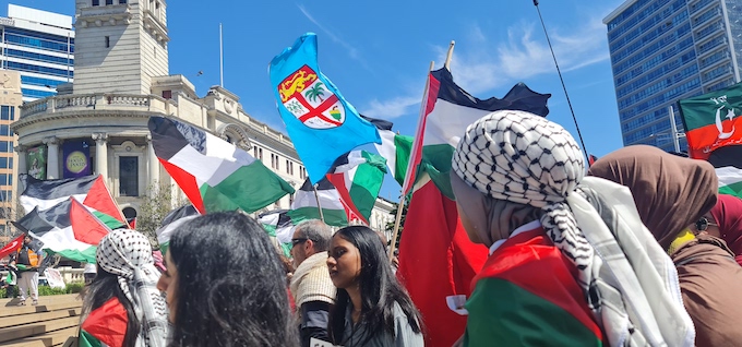 The Fiji flag flies high in the middle of the pro-Palestinian demonstrators