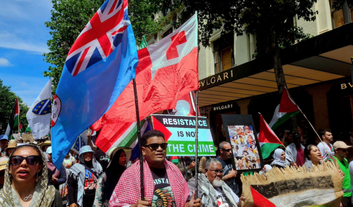 Pro-Palestinian protesters carrying the Fijian and Tongan national flags