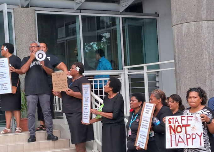 University of the South Pacific staff protesting last November in black with placards calling for “fair pay”