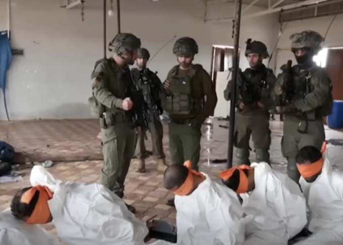 This screenshot from a video broadcast on Israeli channel Now 14 shows an officer and four soldiers of Israel’s Givati Brigade standing next to Palestinian detainees