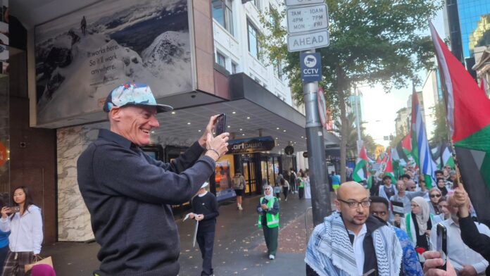 Palestine Solidarity Network Aotearoa (PSNA) co-chair John Minto surveys the protest march up Queen Street in Tāmaki Makaurau Auckland