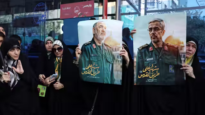 Iranians hold posters of late Islamic Revolutionary Guard Corps head Hossein Salami (left), and late Iranian Armed Forces Chief of Staff General Mohammad Bagheri (right), who were killed in Israeli airstrikes in recent days