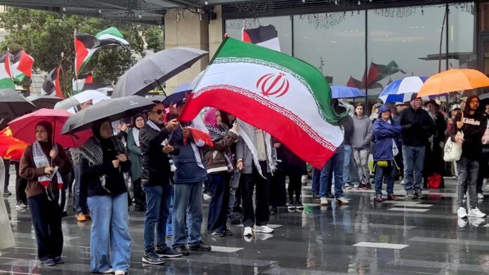Iranian and Palestinian flags at a solidarity rally in Tāmaki Makaurau Auckland today