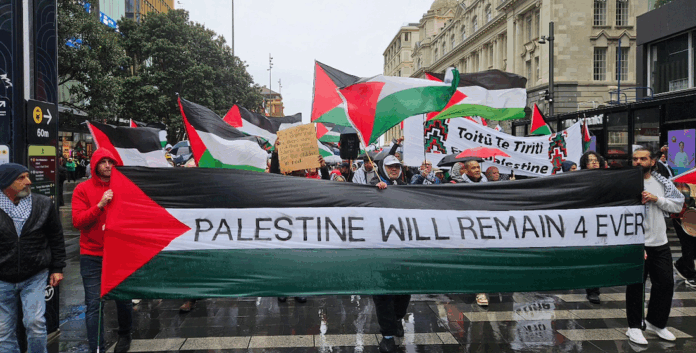 A “Palestine forever” banner at the head of the Auckland march today as it prepares to walk up Queen Street