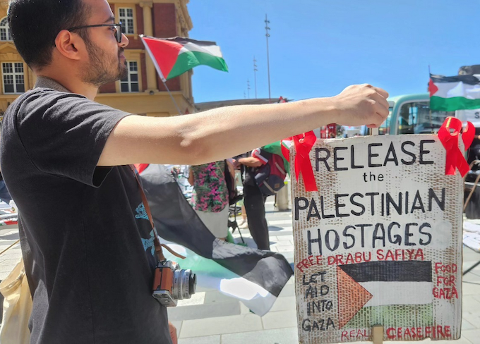 A "release the Palestinian hostages" placard at today's Red Ribbon Campaign protest in Auckland's Te Komititanga Square