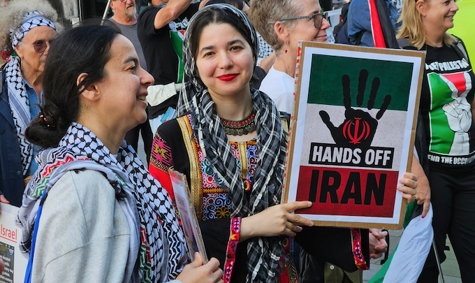 Two women protesters with a “Hands off Iran” placard