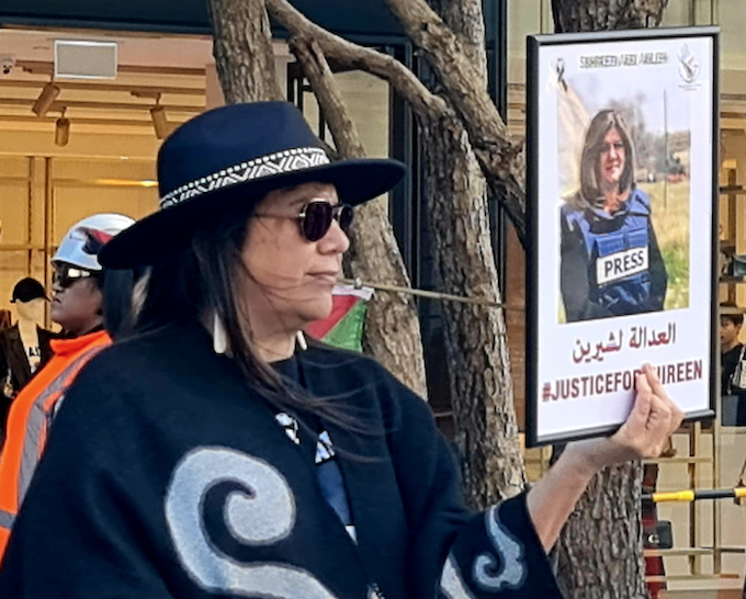 PSNA protest organiser Leeann Wahanui-Peters holds aloft the author’s photo of assassinated Palestinian-American journalist Shireen Abu Akleh